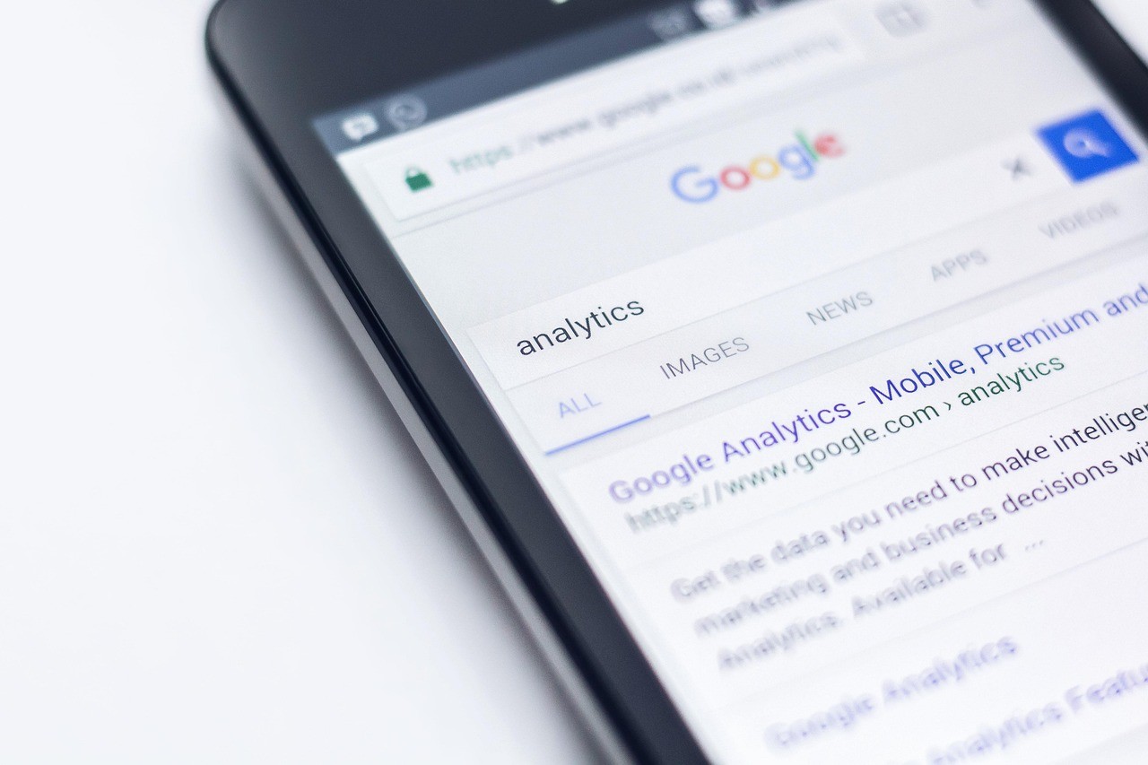 Smartphone tenu en main affichant une recherche Google dans le navigateur mobile