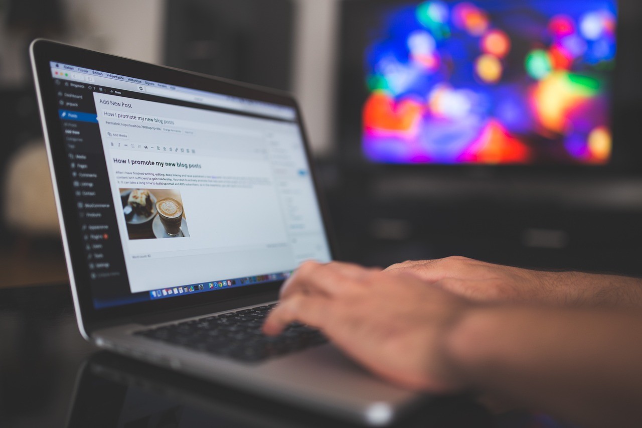 Un entrepreneur rédige un article sur son site depuis un ordinateur portable