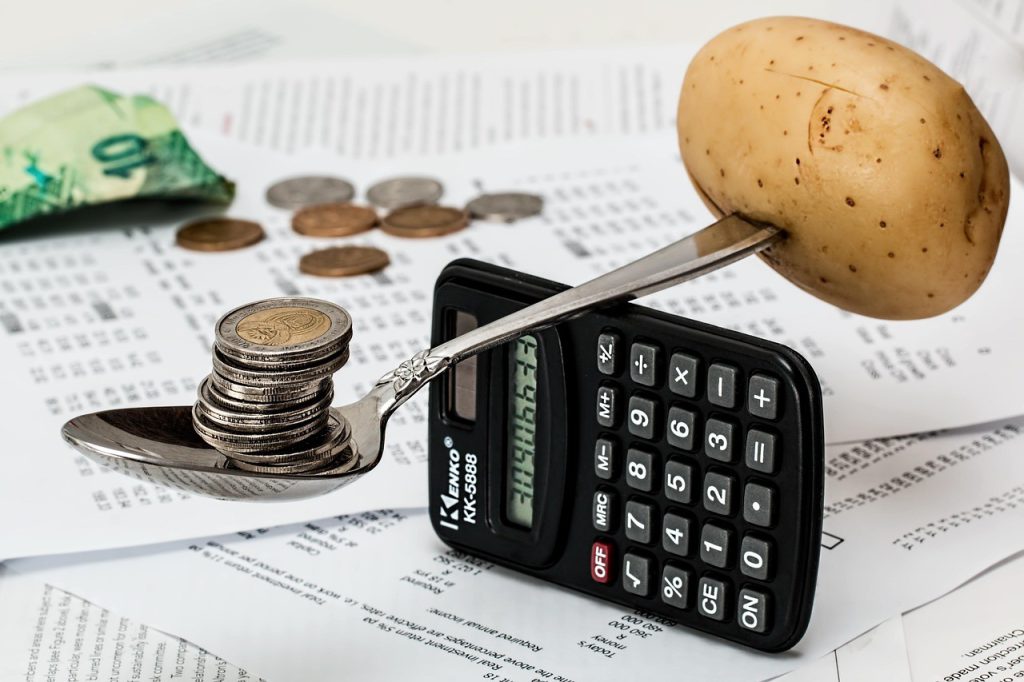 Calculatrice et pièces de monnaie posées sur un budget en cours de préparation