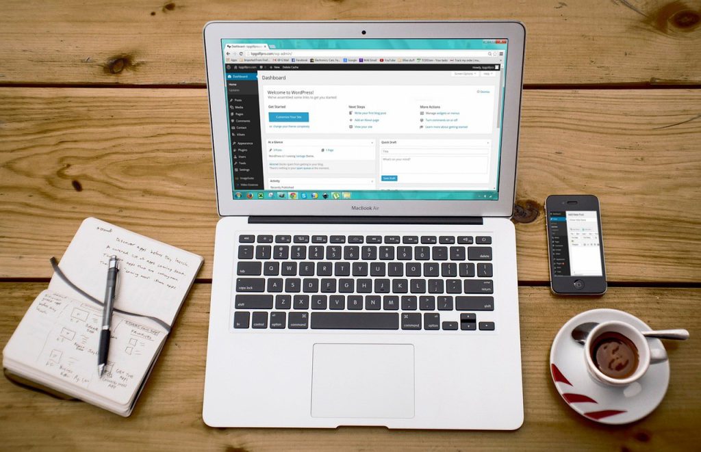Ordinateur portable affichant le tableau de bord WordPress, avec carnet de notes et smartphone