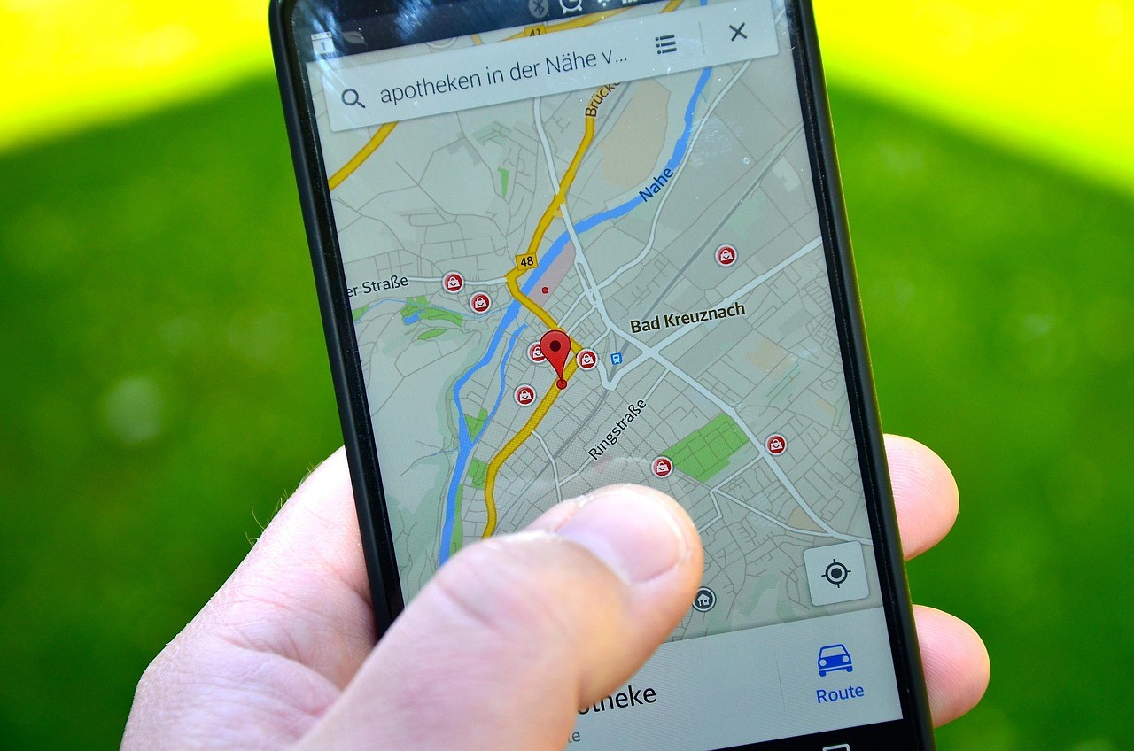 Main tenant un smartphone affichant un plan de navigation avec des commerces géolocalisés