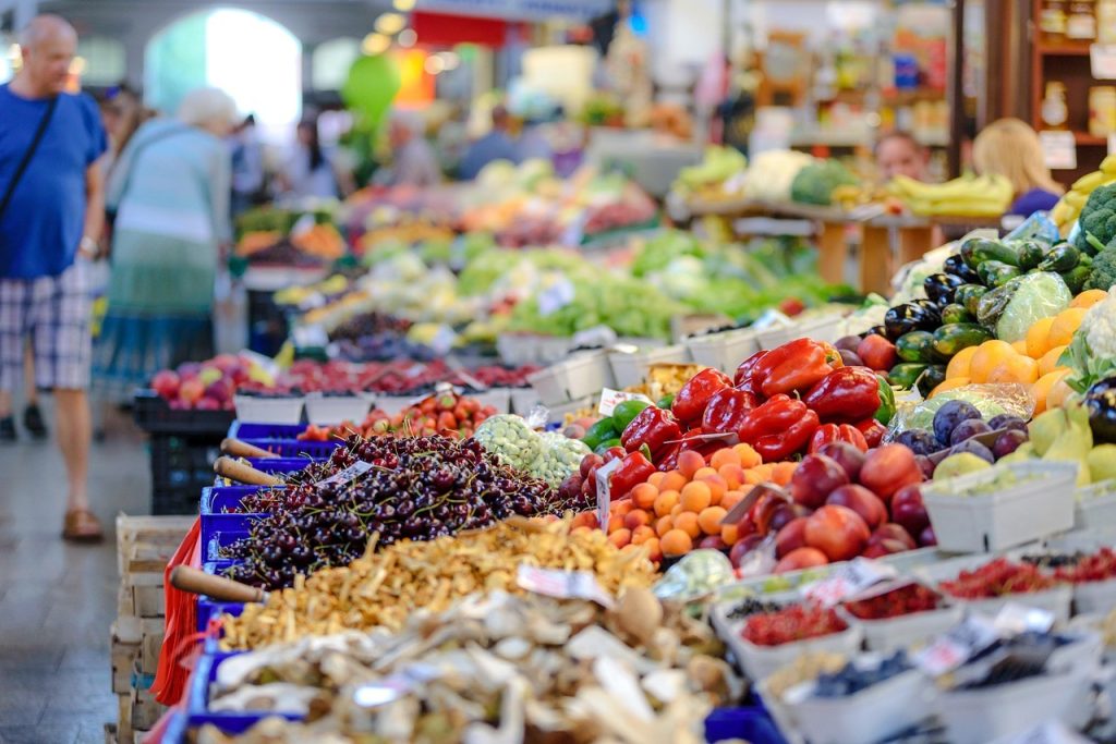 Étals colorés d'un marché de produits frais, illustrant le commerce de proximité