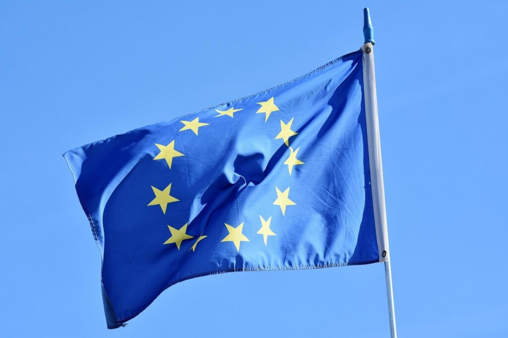 Drapeau de l'Union européenne flottant dans le ciel, symbole du cadre réglementaire européen (DMA) qui encadre Google