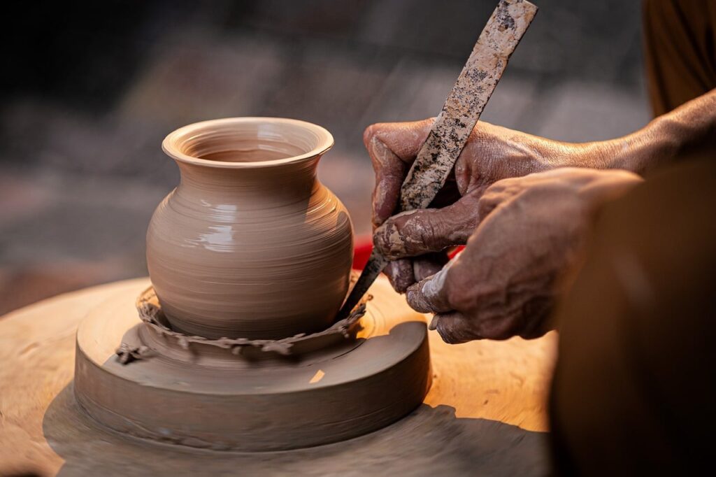 Artisan potier façonnant une pièce à la main, symbole du savoir-faire réel d'une petite entreprise