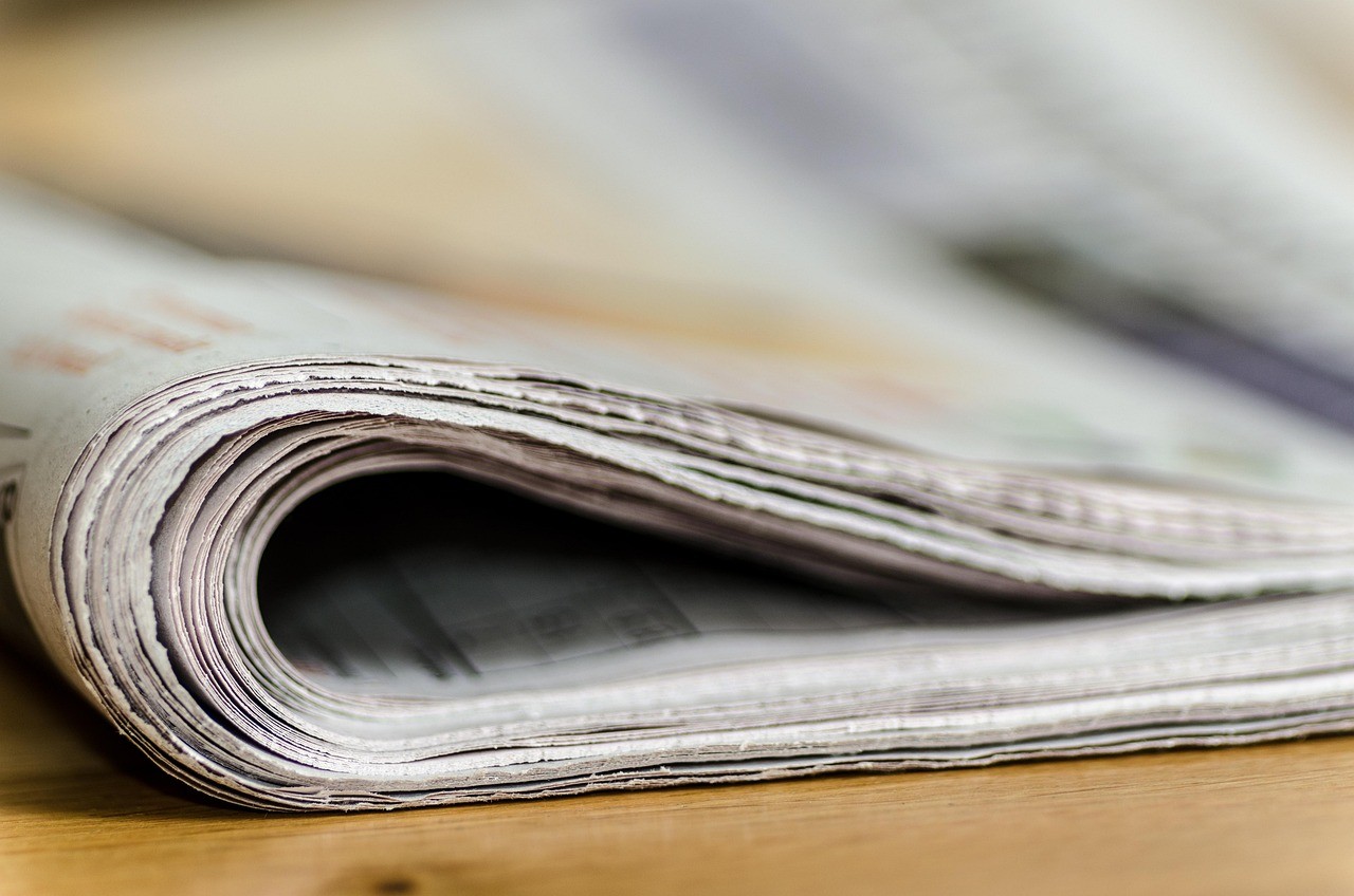 Pile de journaux et de communiqués de presse syndiqués