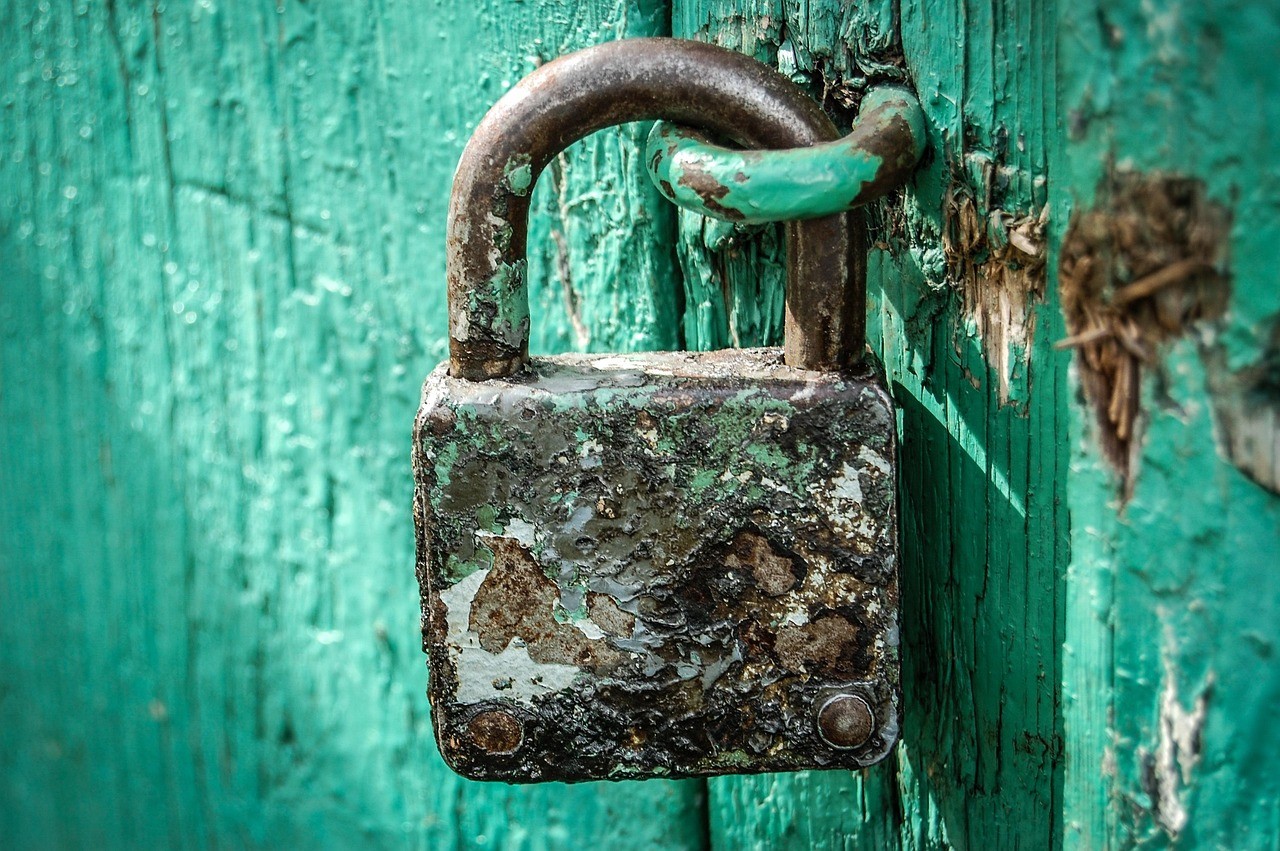 Vieux cadenas verrouillé sur une porte en bois, symbole d'une faille refermée