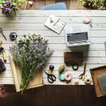 Propriétaire d'une petite boutique (fleuriste) qui consulte son site en ligne depuis un ordinateur portable, sur son établi