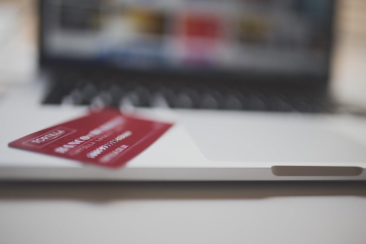 Carte bancaire posée près d'un ordinateur portable pour illustrer un paiement en ligne sécurisé