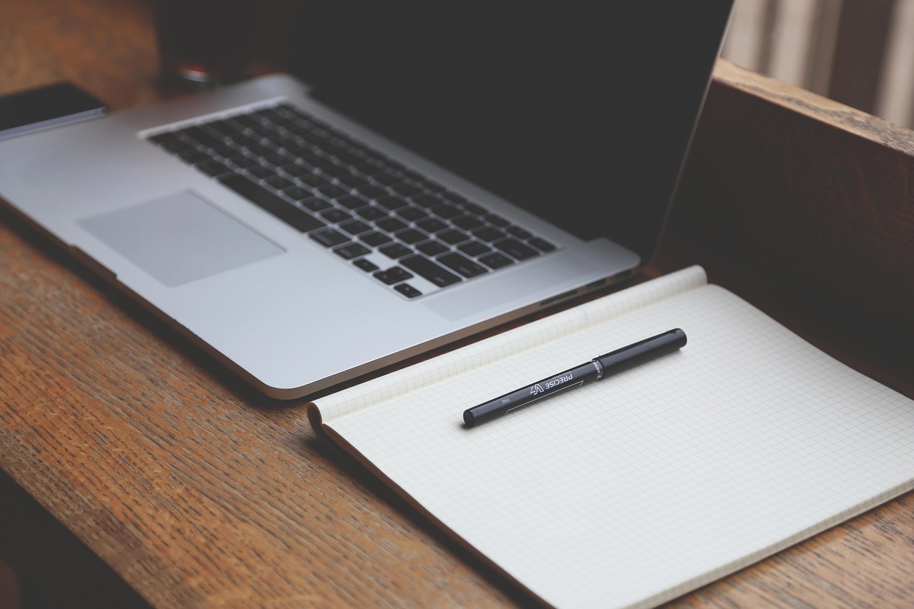 Bureau avec ordinateur portable, carnet et stylo, poste de travail pour un contrôle technique de site