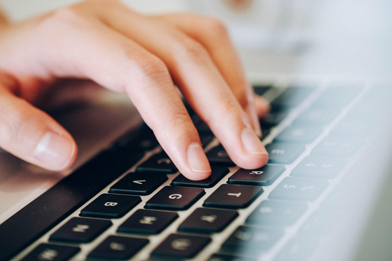 Doigt appuyant sur une touche de clavier d'ordinateur portable