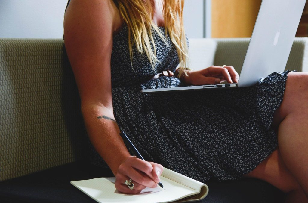 Une entrepreneuse travaille sur son ordinateur portable, assise sur un canapé