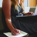 Une entrepreneuse travaille sur son ordinateur portable, assise sur un canapé