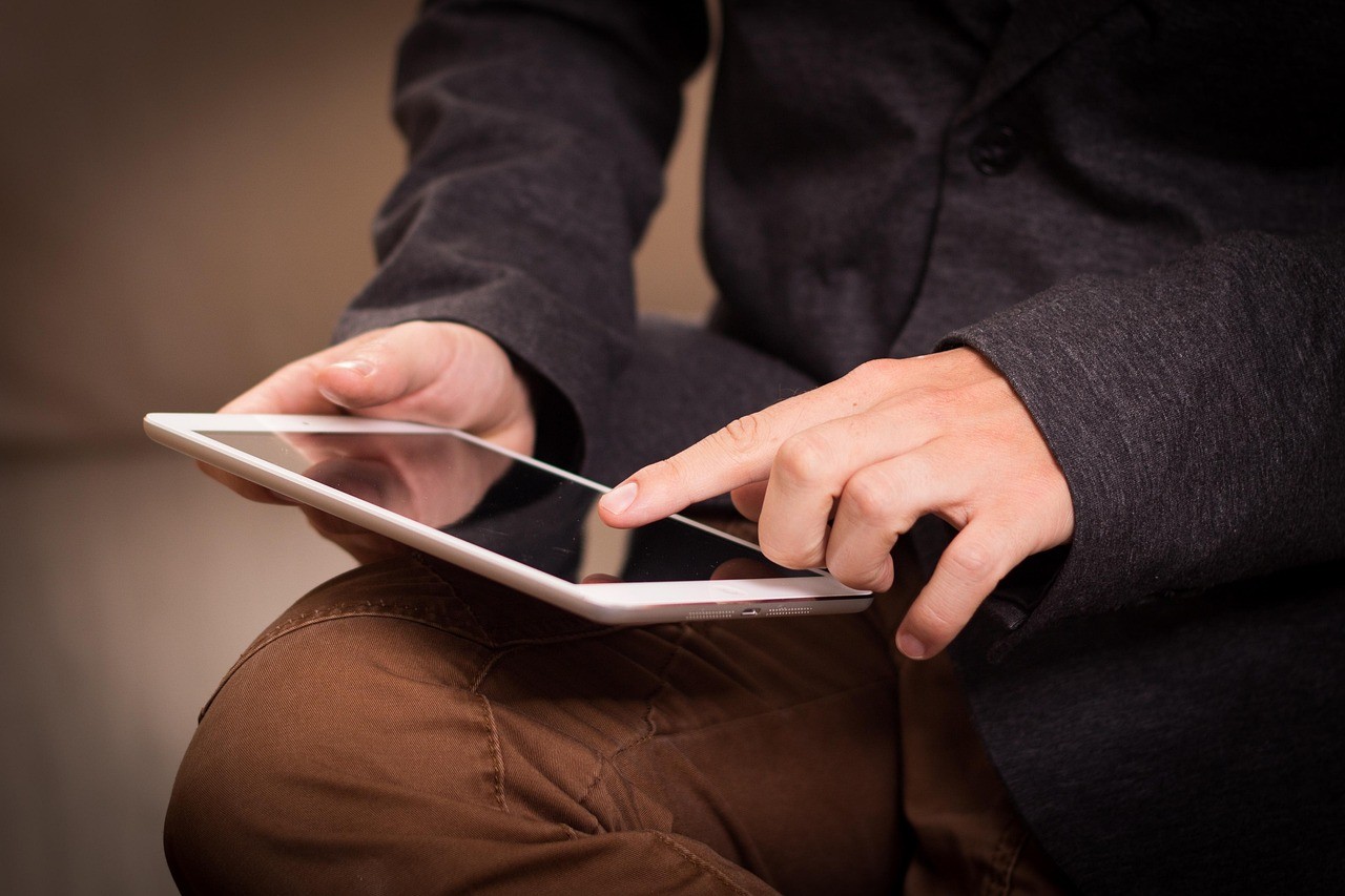 Personne qui consulte une tablette tactile pour vérifier son site