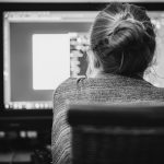 Personne de dos travaillant sur un ordinateur dans un bureau à domicile