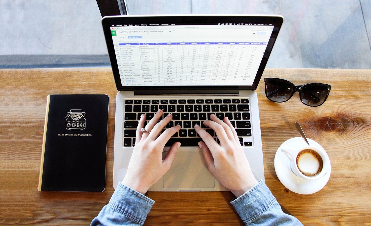 Personne tapant au clavier d'un ordinateur portable pour rédiger un texte